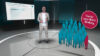 Ausschnitt aus dem Erklärvideo zu den Ergebnissen der LA-MED Facharzt-Studie 2026, Thema: Fachgruppe Gynäkologie. Ein Moderator steht in einem von KI konstruierten virtuellen Fernsehstudio, hinter sich ein Bildschirm mit eingeblendeten Balkendiagrammen.